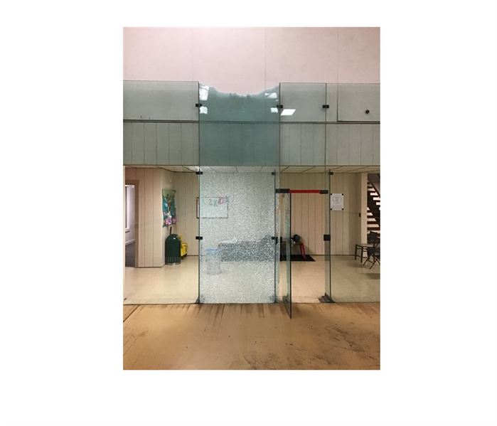 shattered glass doors in commercial building with wood floors